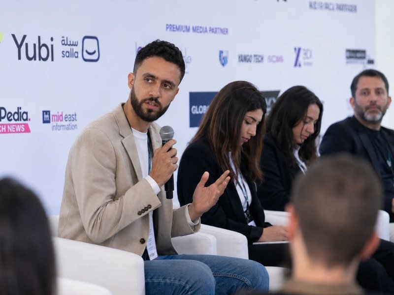 Mohamed Arfaoui speaking into a microphone during a panel discussion