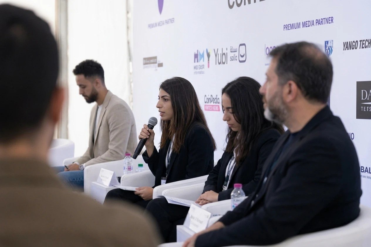 Mohamed Arfaoui seated on a panel next to other speakers during a conference